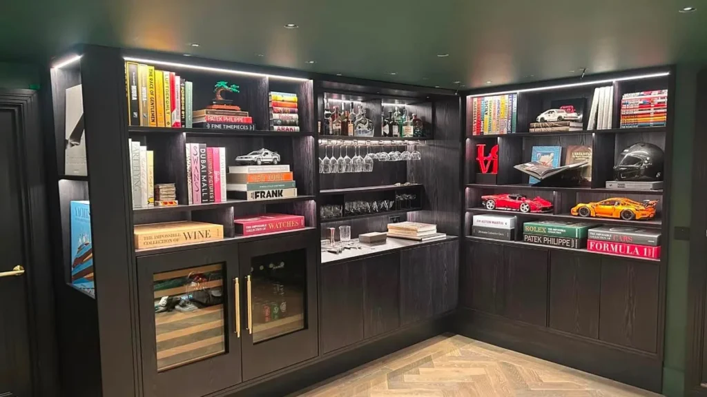 Bespoke joinery Jersey - handmade dark cabinetry with lit display shelving